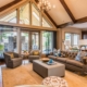 gold updated living room with beamed ceilings and brown area rug.