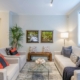 living room with a throw rug, blue pillows and a glass coffee table,