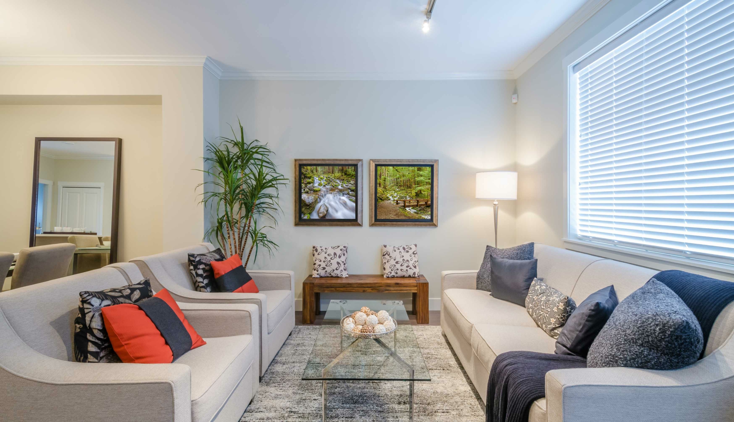 living room with a throw rug, blue pillows and a glass coffee table,