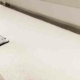 cleaning white carpet with a wand