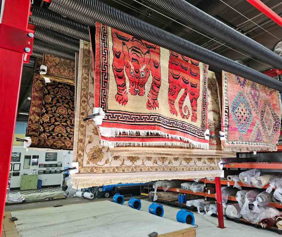 brightly patterned rugs drying on a drying rack